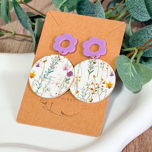 Lavender flower top earrings with round wildflower print circles displayed on a brown Bee Marie Market card.