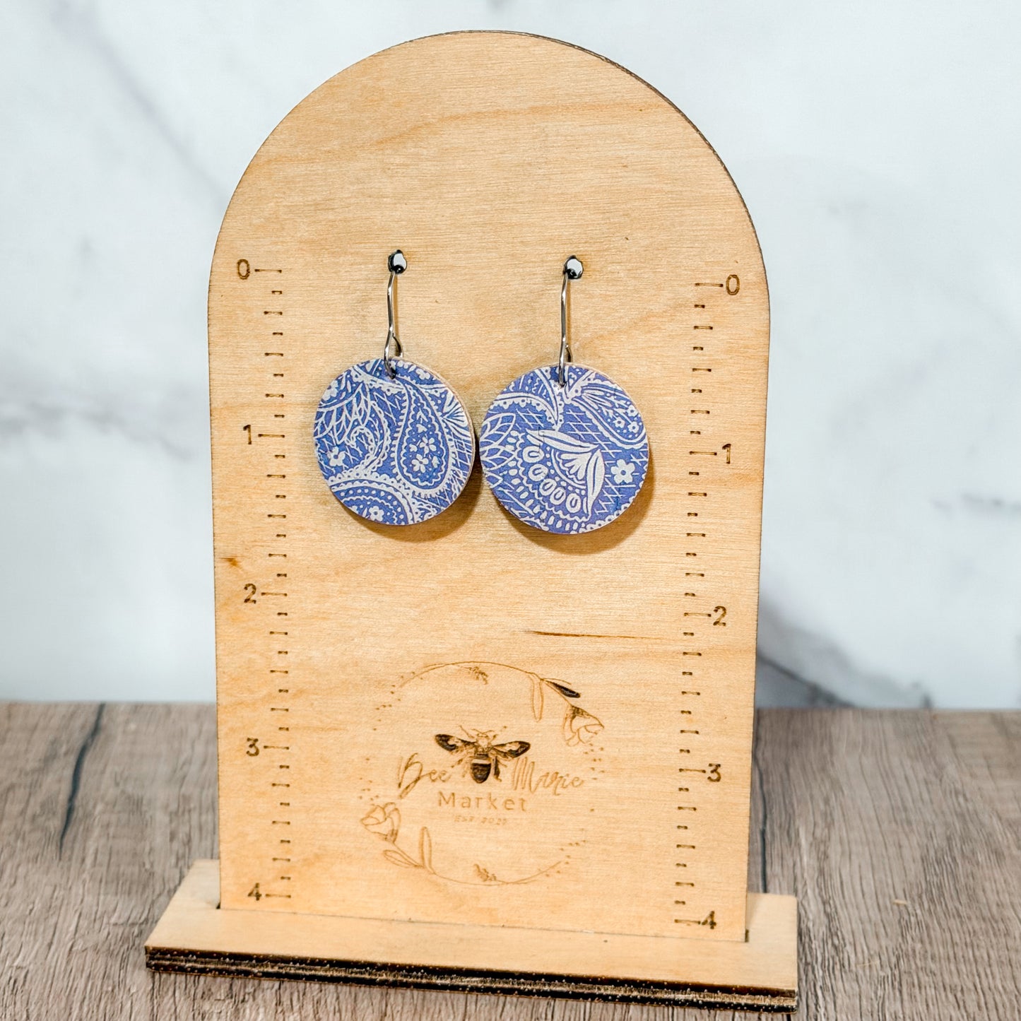 Pastel purple paisley leather earrings photographed on a clean background with hypoallergenic hooks. Handmade lightweight pair with unique pattern placement.