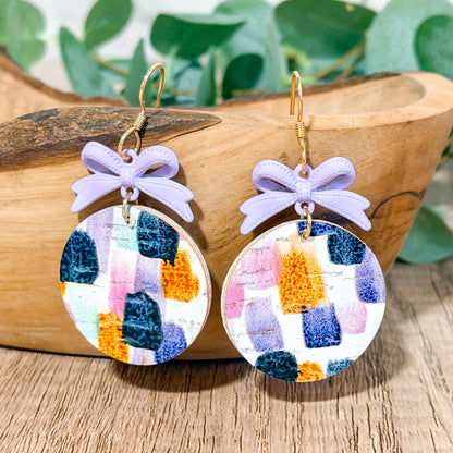 Lavender bow earrings with colorful brushstroke leather circles.