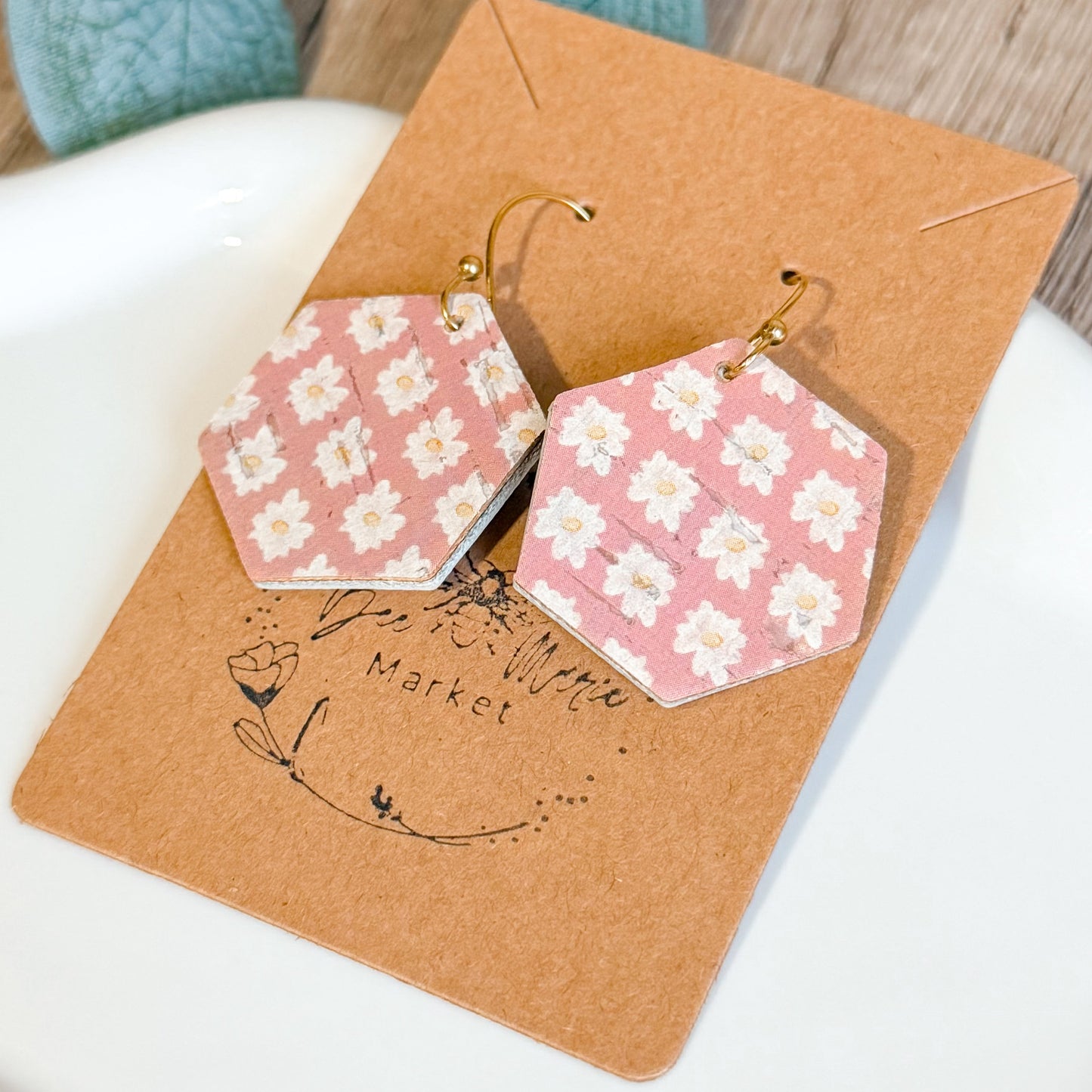 Hexagonal earrings with floral pattern on a brown card with 'The Little Market' branding.