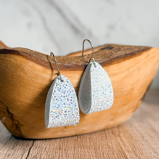 Loop hoop earrings with glittery finish on a wooden surface