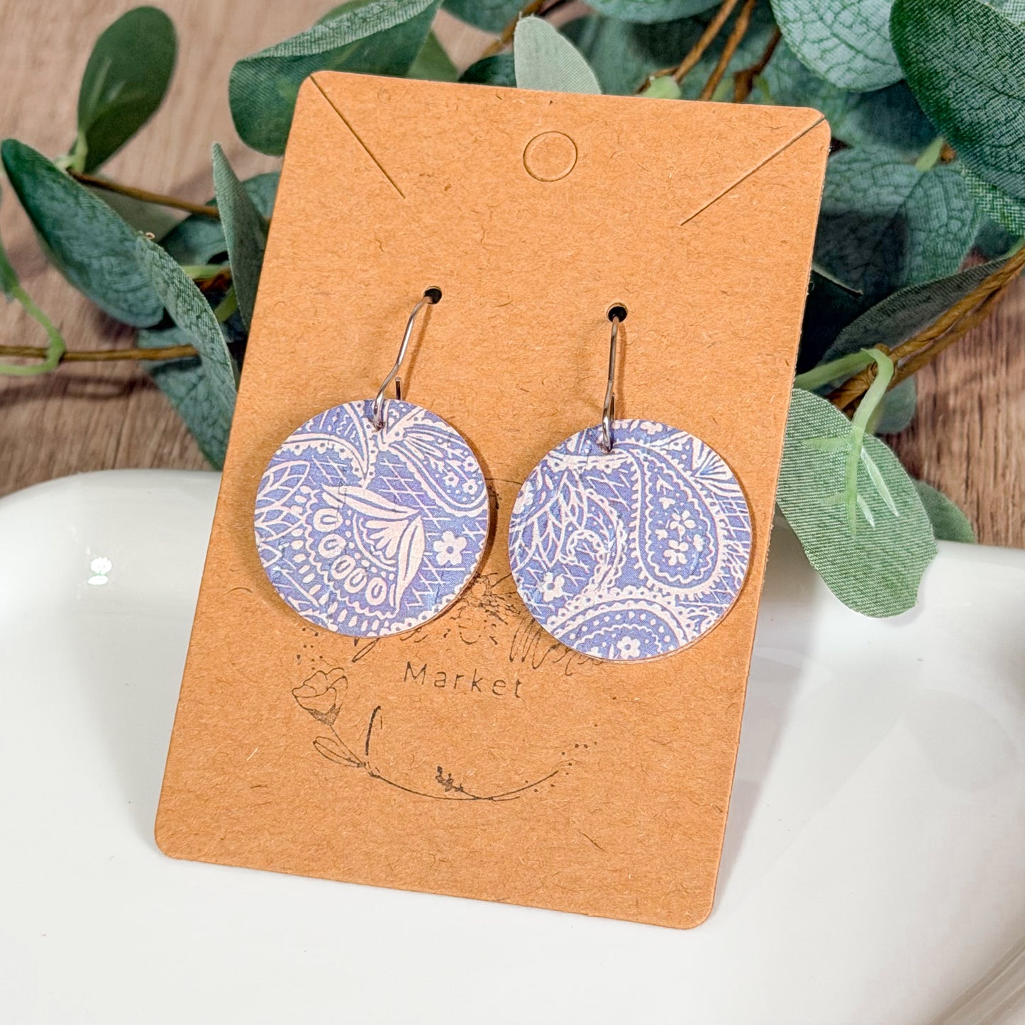 Pastel purple paisley leather earrings photographed on a clean background with hypoallergenic hooks. Handmade lightweight pair with unique pattern placement.