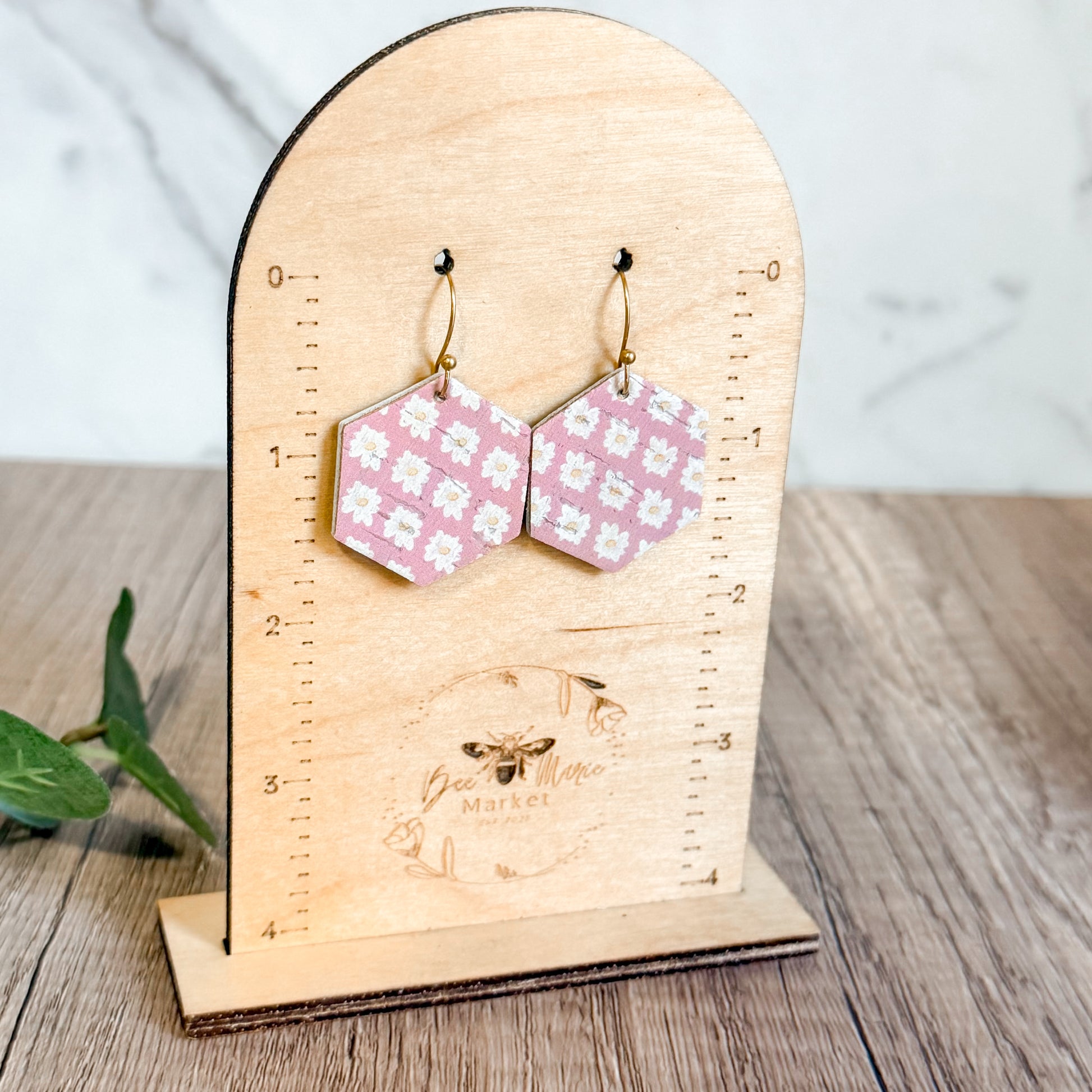 Hexagonal patterned earrings on a wooden stand with 'Bee Mine Market' branding.