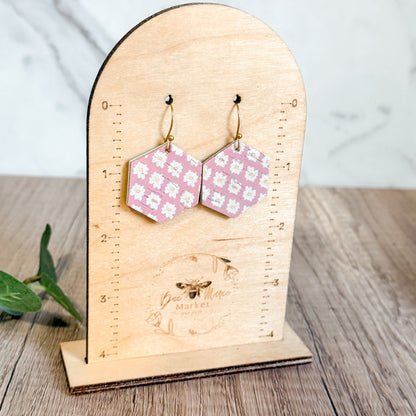 Hexagonal patterned earrings on a wooden stand with 'Bee Mine Market' branding.