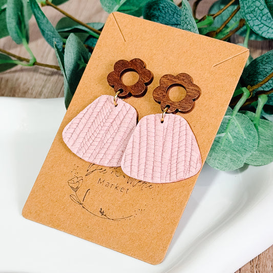 Light pink textured leather earrings with wooden flower studs displayed on a Bee Marie Market card.