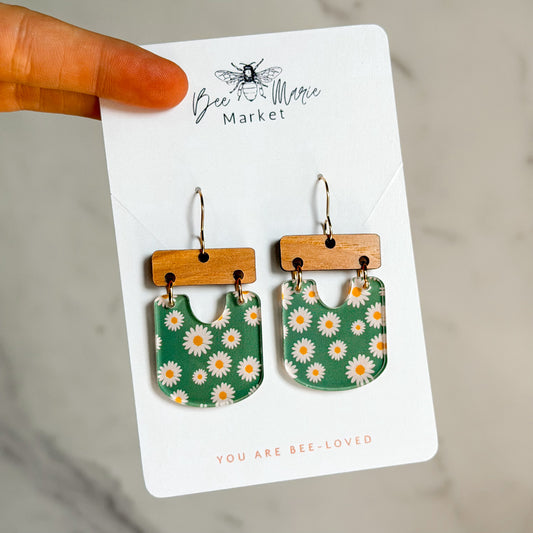 Green floral earrings on a 'Bee Magic Market' branded card.