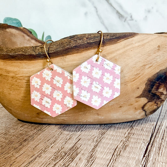 Hexagonal earrings with floral pattern on a wooden surface