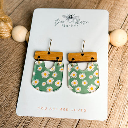 Pair of floral earrings on a 'Bee & Flower Market' card with wooden accents.