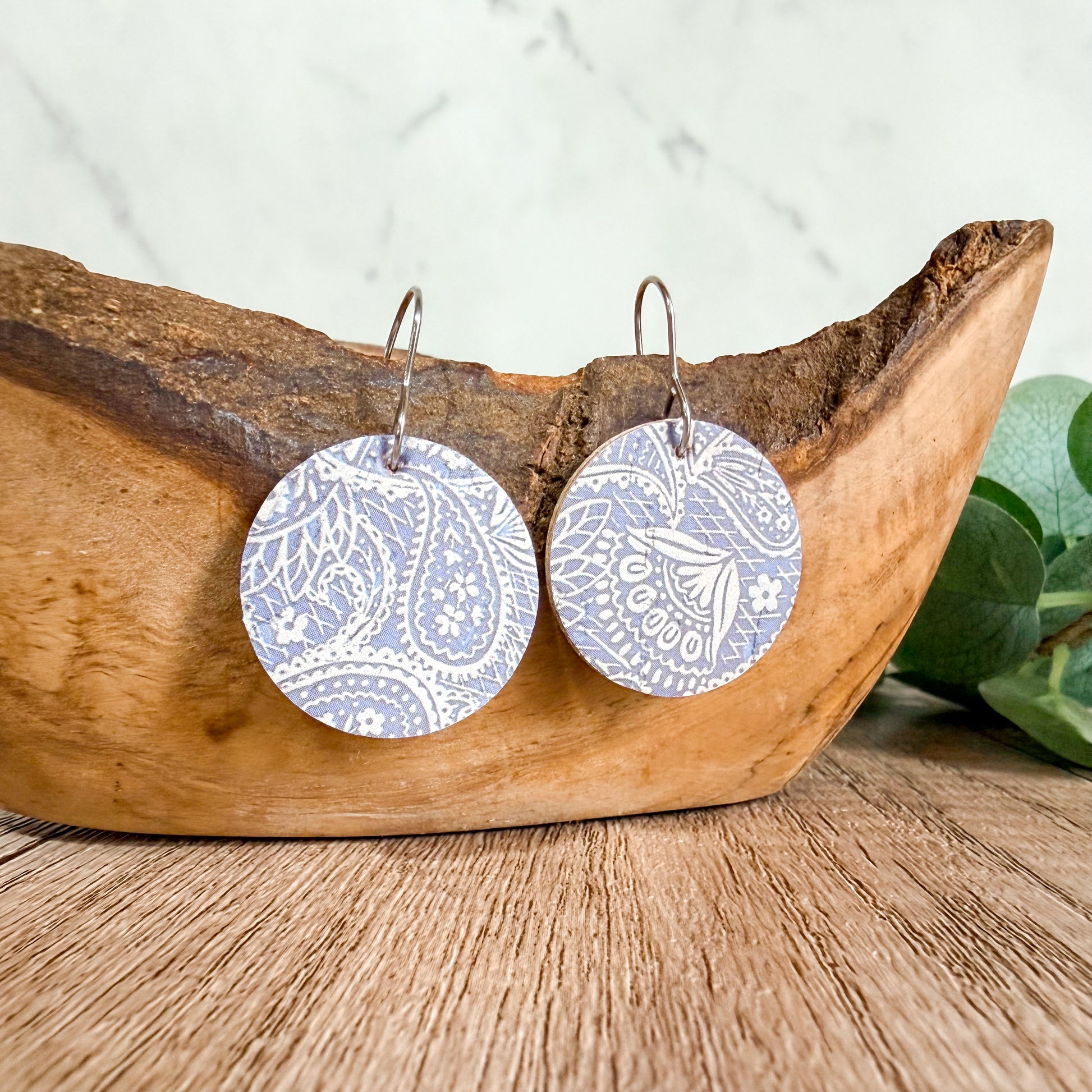 Pastel purple paisley leather earrings photographed on a clean background with hypoallergenic hooks. Handmade lightweight pair with unique pattern placement.