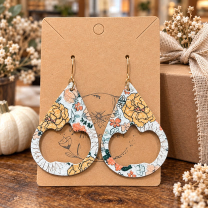 Autumn floral pumpkin cutout earrings on display card in boutique setting