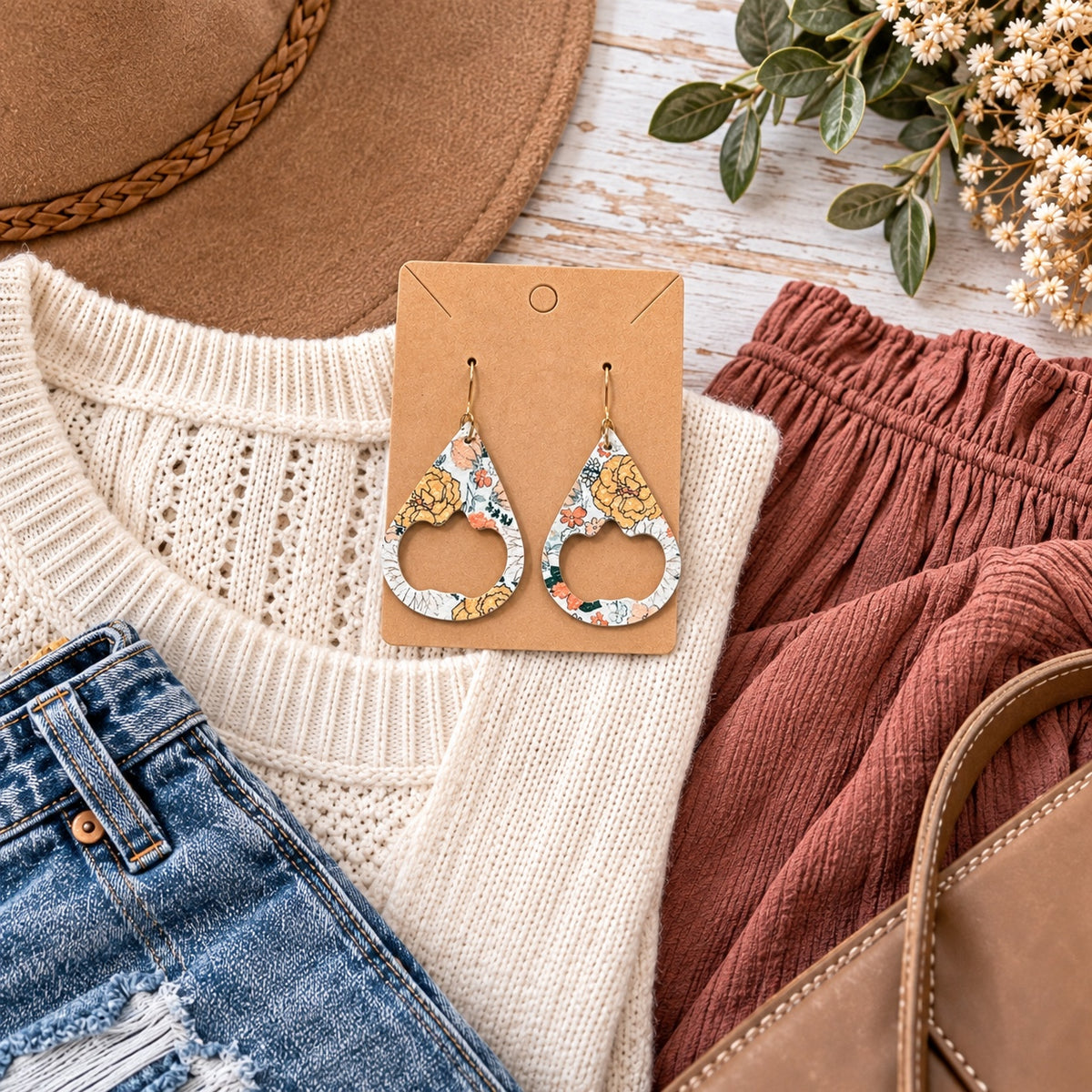 Autumn floral pumpkin cutout earrings with coordinated fall outfit flat lay