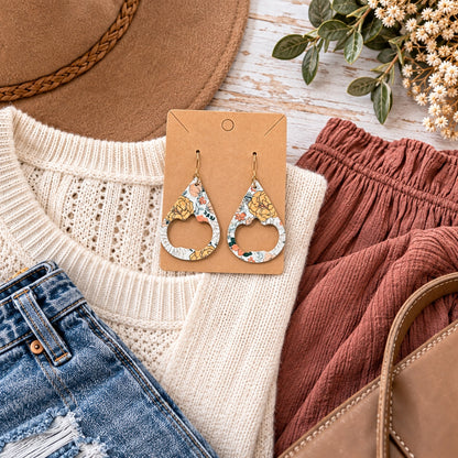 Autumn floral pumpkin cutout earrings with coordinated fall outfit flat lay