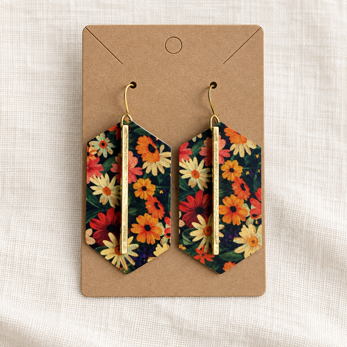 Pair of dark floral gold bar earrings on a kraft display card