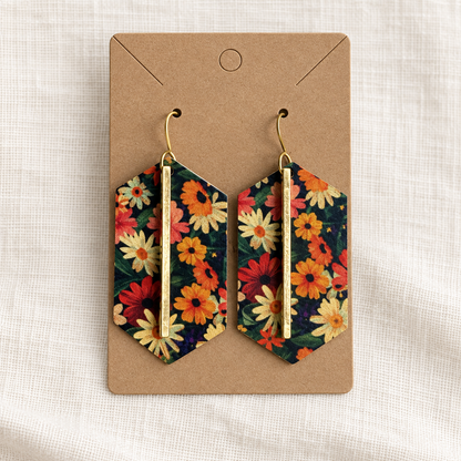 Pair of dark floral gold bar earrings on a kraft display card