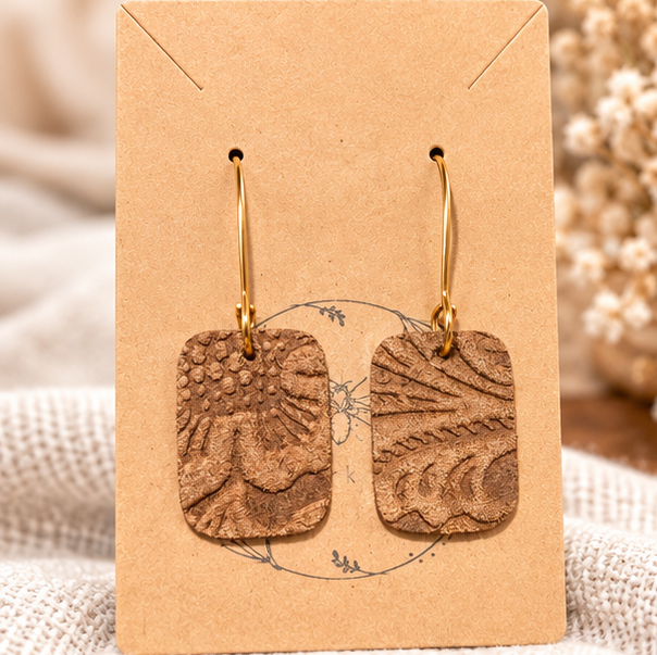 Brown embossed leather rectangle earrings on display card