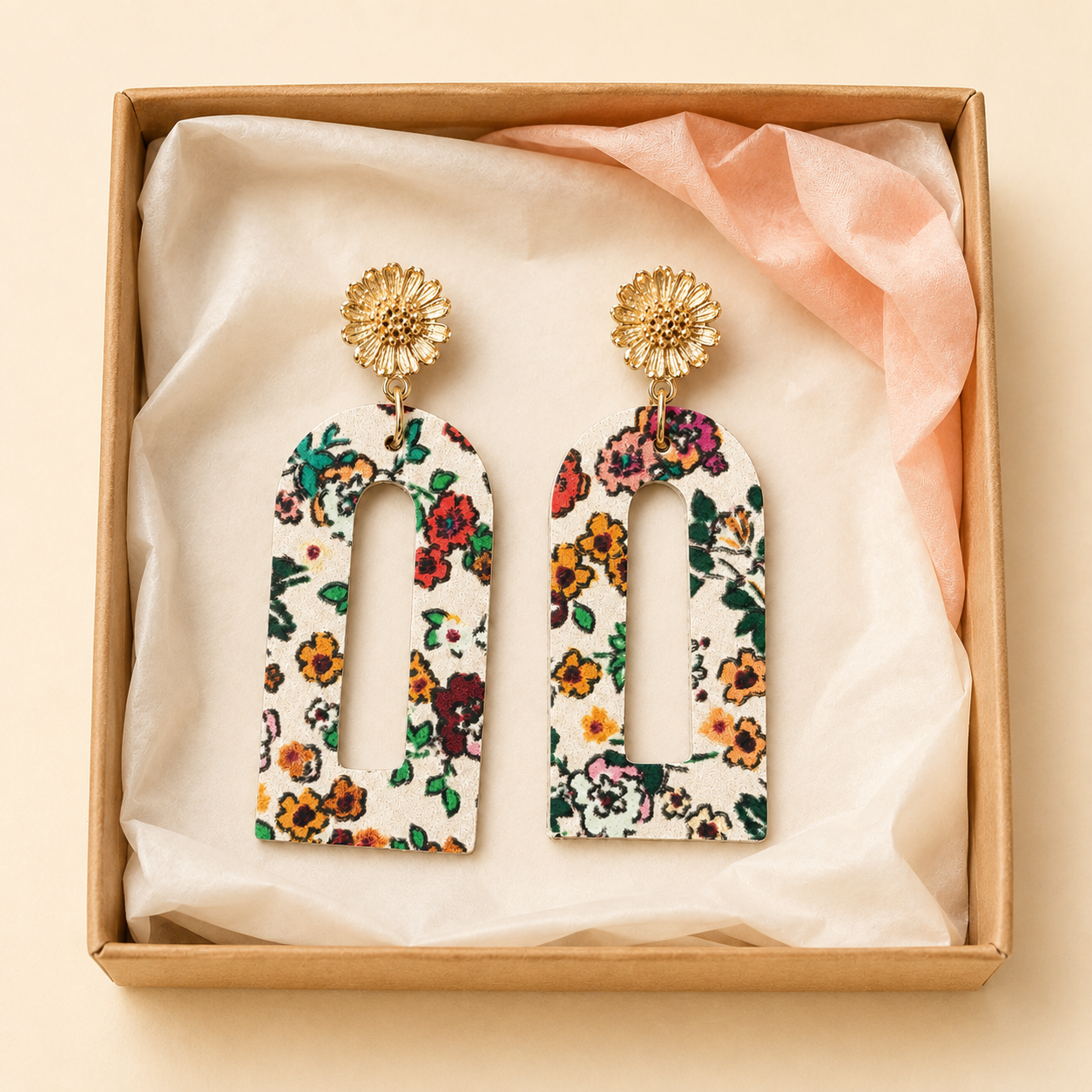 Cream floral arch earrings presented in a kraft gift box with cream and peach tissue.