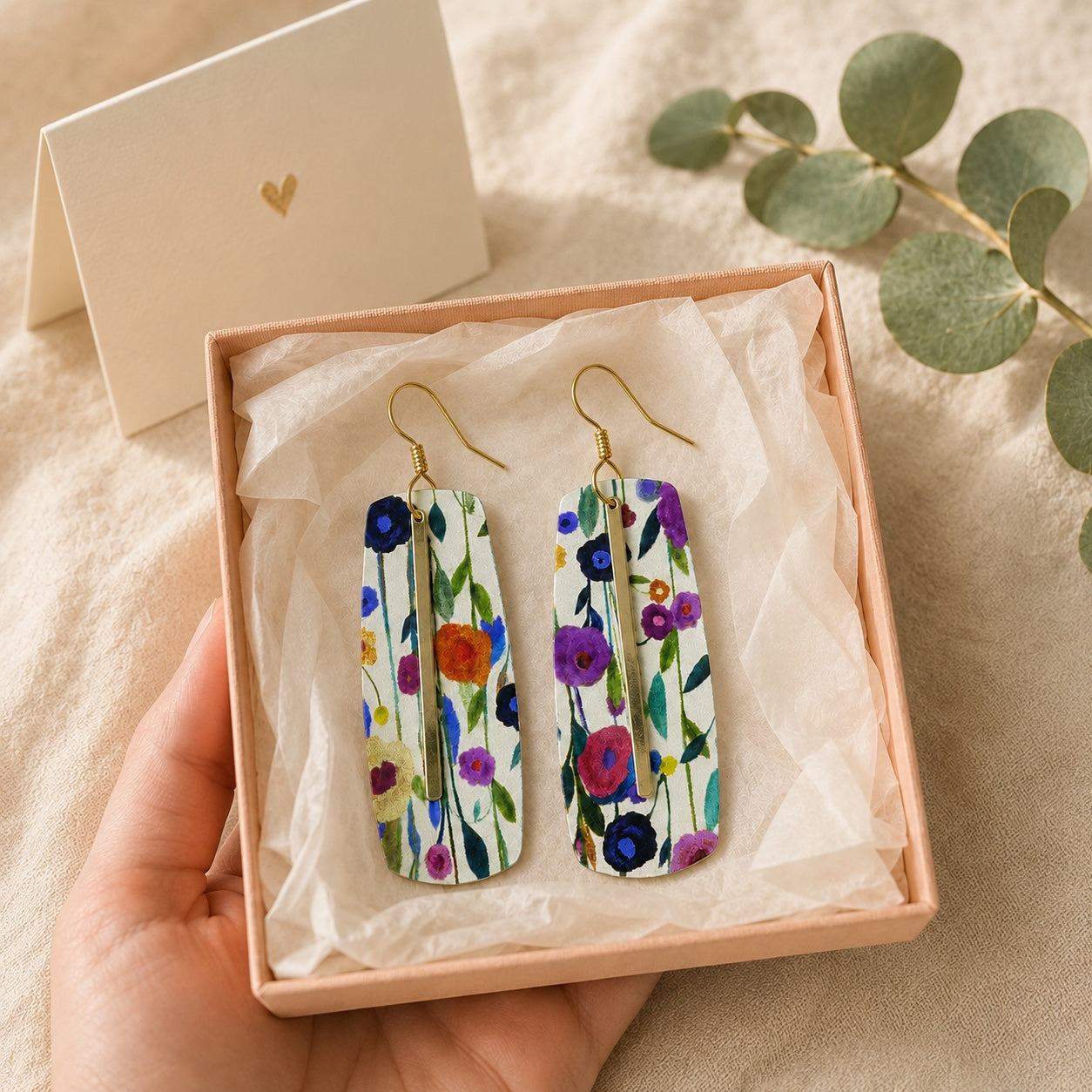 Floral bar earrings displayed in an open peach gift box with a greeting card.