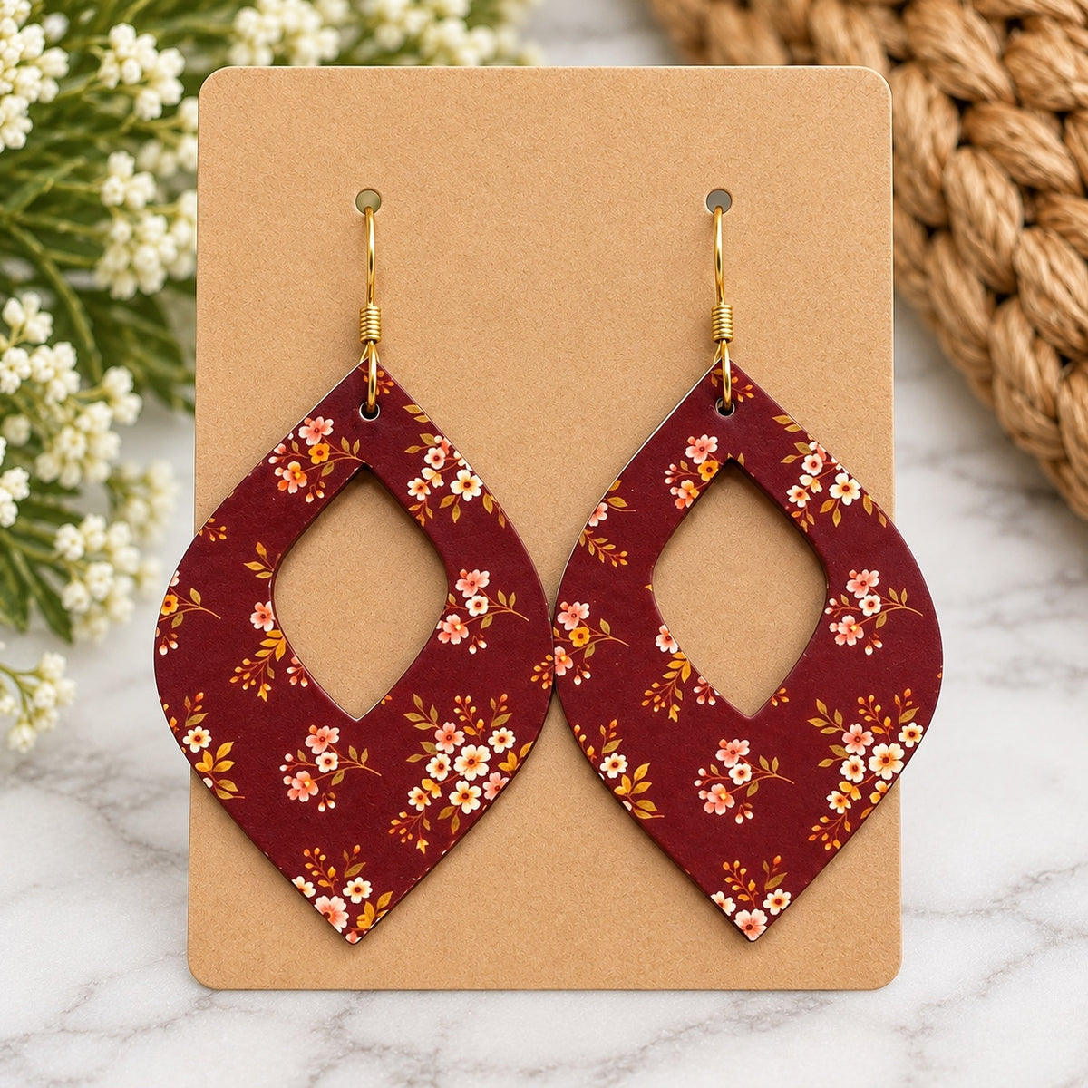 Maroon floral open teardrop earrings with gold hooks on a blank kraft card