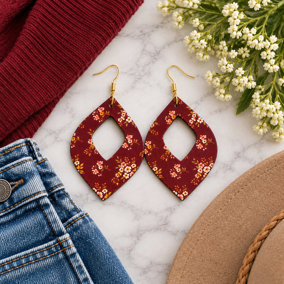 Maroon floral open teardrop earrings styled with a burgundy sweater and denim