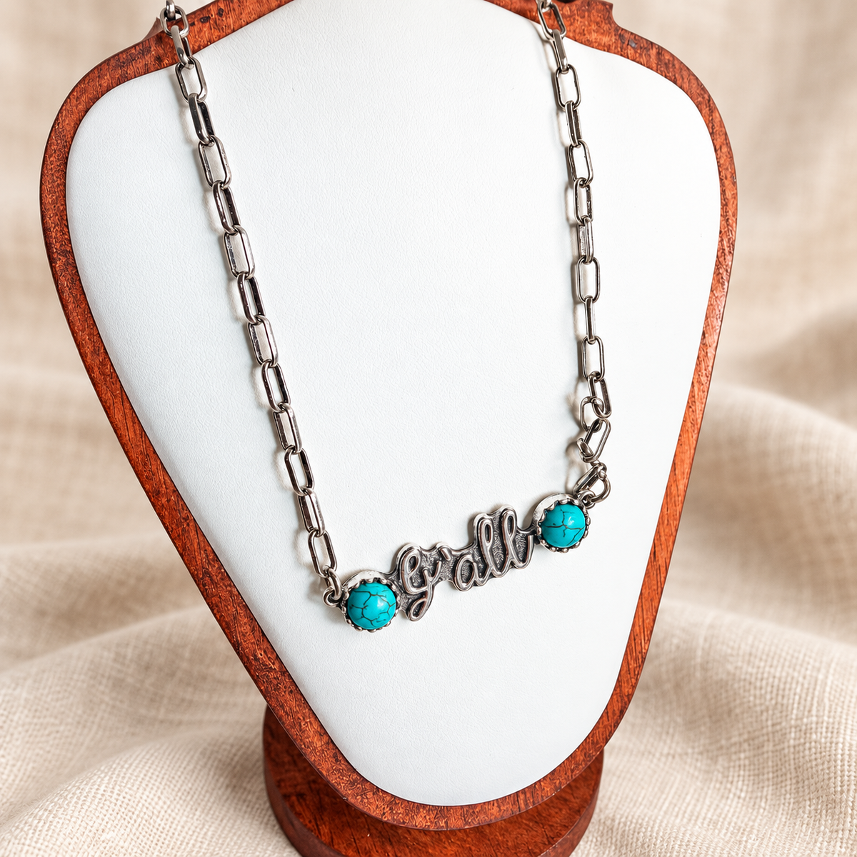Silver y'all necklace with turquoise accents displayed on a white bust