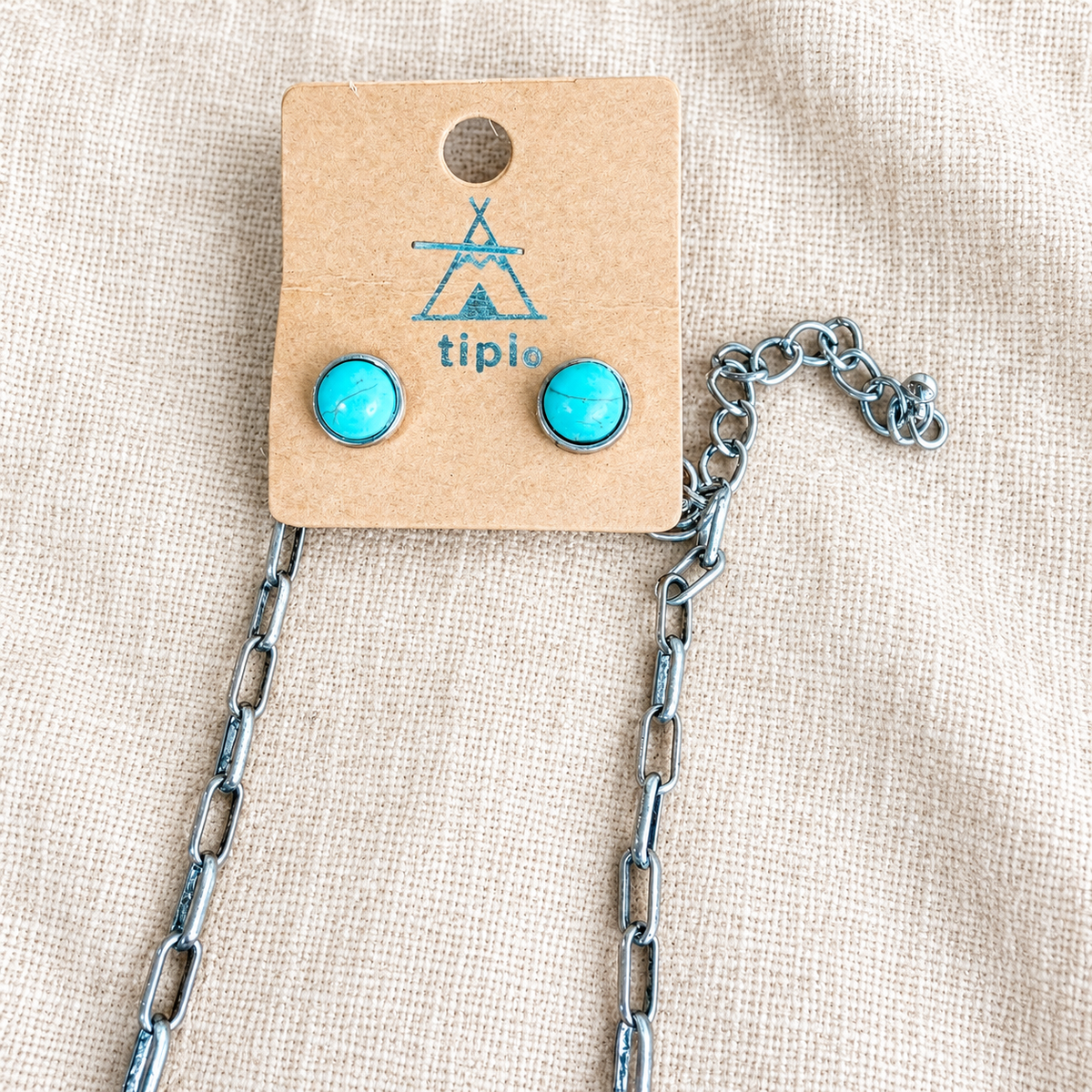 Close view of matching turquoise stud earrings on tiplo card