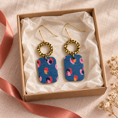 Teal abstract floral leather earrings displayed in a kraft gift box