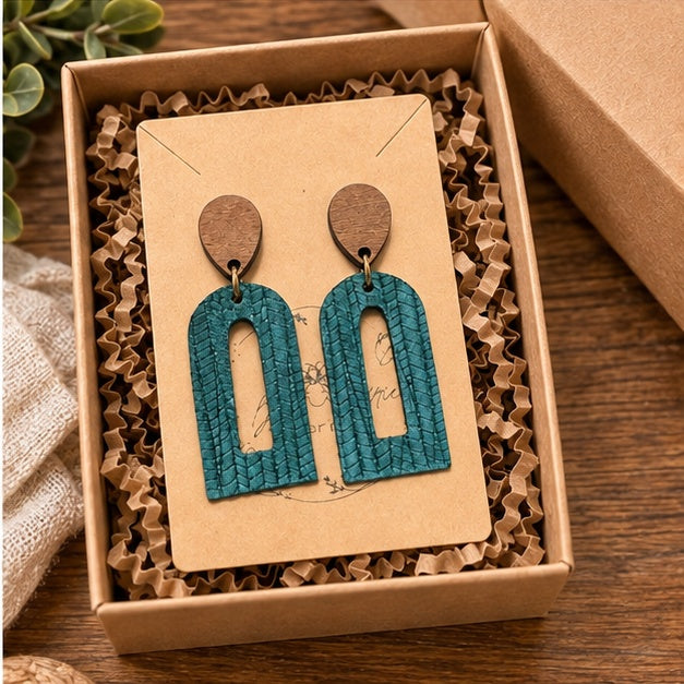 Dark teal palm petite open arch earrings styled in a gift box