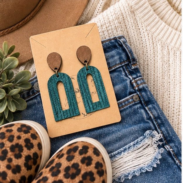 Dark teal palm petite open arch earrings with boutique outfit flat lay