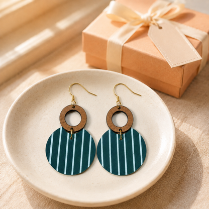 Teal striped earrings styled beside a peach gift box with cream ribbon.