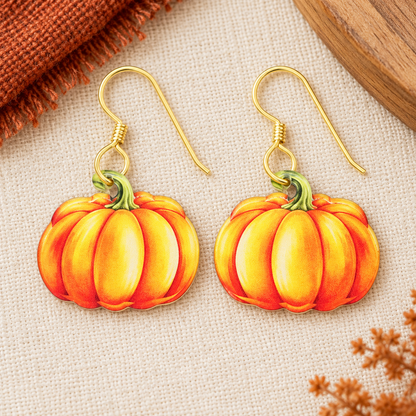 Orange watercolor pumpkin acrylic earrings with gold hooks on ivory linen.